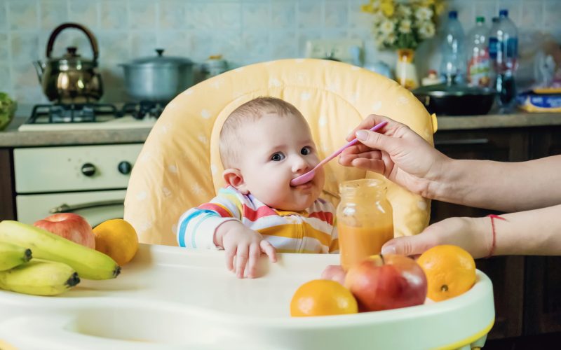 Baby is eating fruit puree. Selective focus. Food.